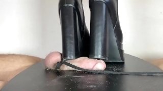 Mistress Elle in black large heels boots trample her slave cock on table