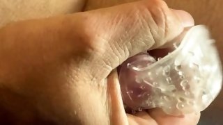 Masturbation of a cock in a rubber condom.
