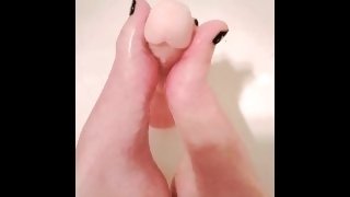 Lubed up dildo gets a sloppy footjob in the shower