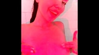 Baby in the shower rubs her bare tits.