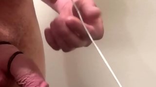 9mm rosebud sounding rod inserted in urethra of big white cock